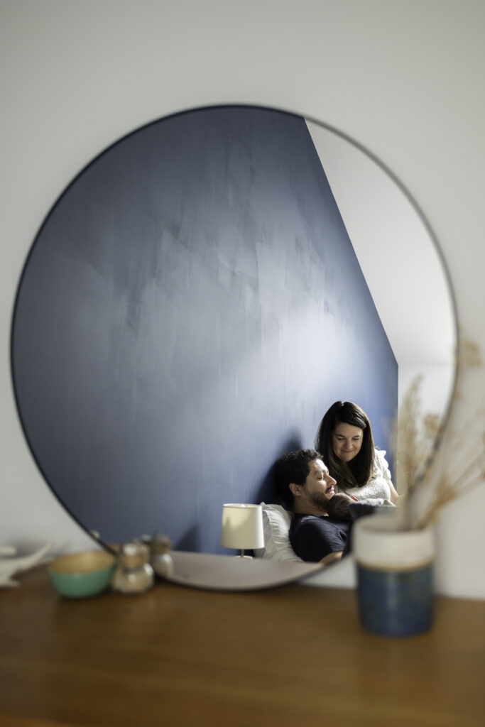 parent faisant un câlin à leur bébé pris en photo dans le reflet d'un miroir